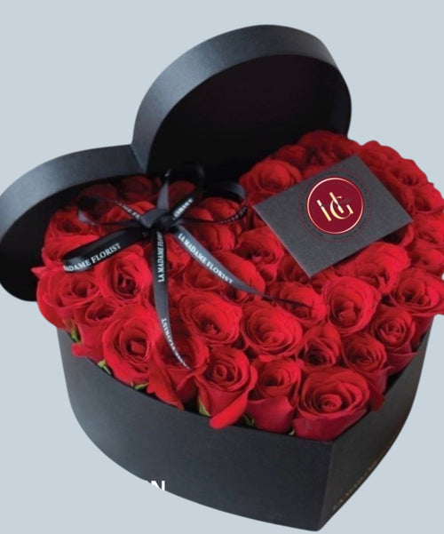 Caja corazón negra con rosas rojas frescas y listón negro