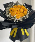 Golden yellow roses with baby's breath in black wrap with yellow and black ribbon