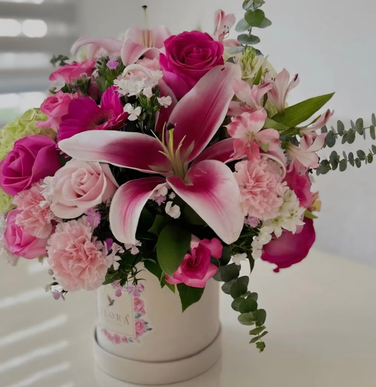 Stargazer lily and pink roses arrangement in white hat box