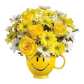 Ramo de rosas y margaritas amarillas y blancas en una taza de cerámica con carita feliz