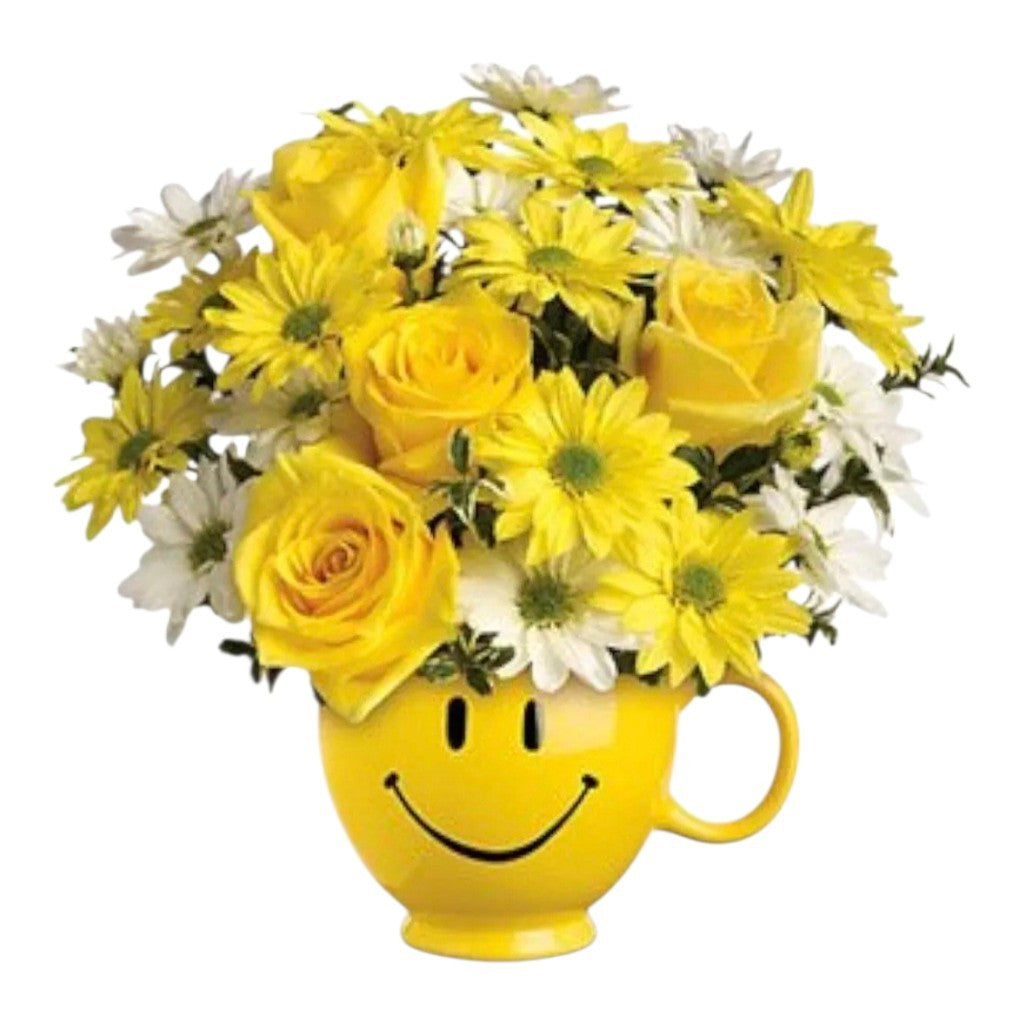 Ramo de rosas y margaritas amarillas y blancas en una taza de cerámica con carita feliz