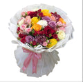 Ramo grande de rosas multicolor y claveles envuelto en papel blanco con moño rosa