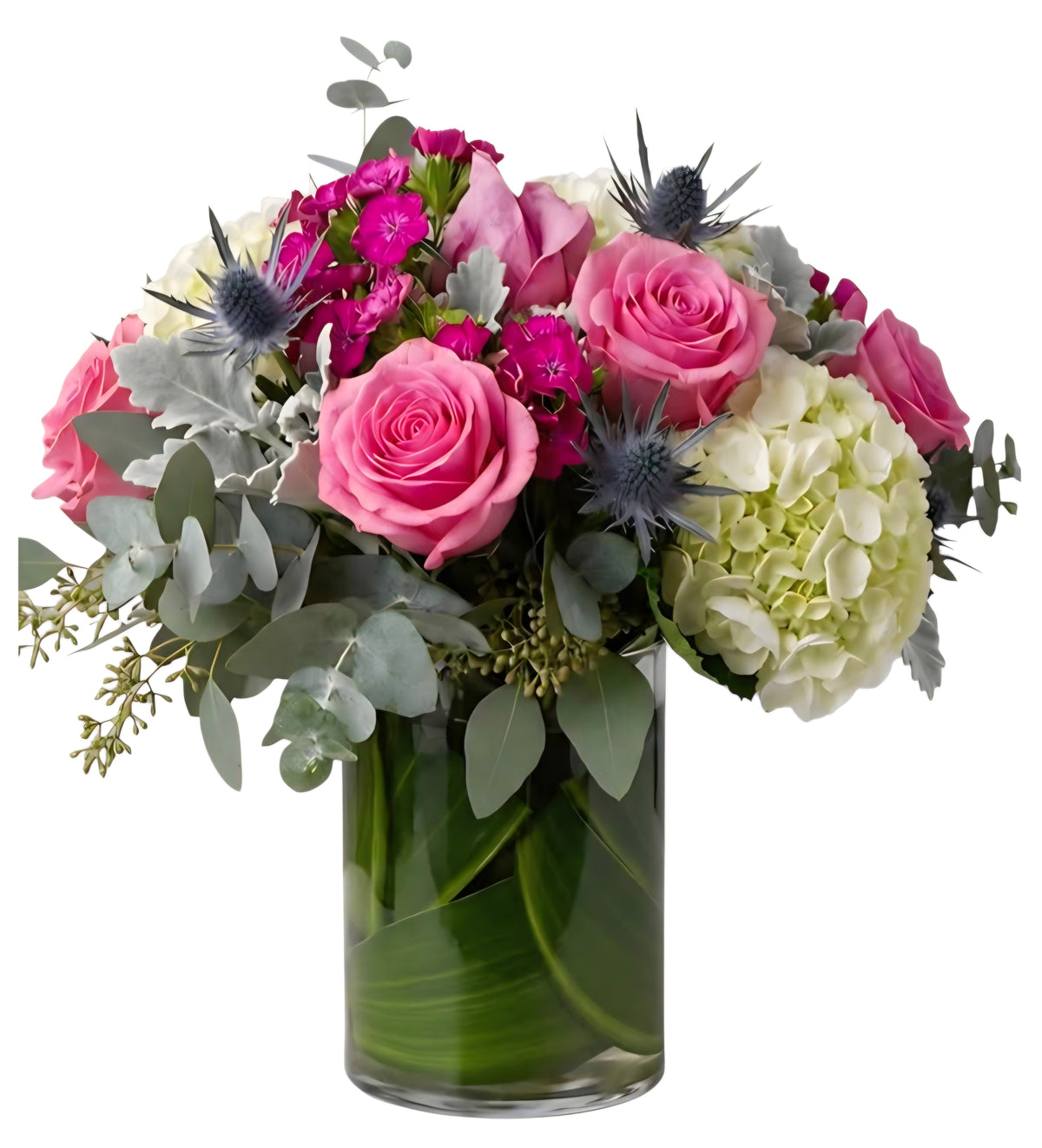 Arreglo de rosas rosadas, hortensia blanca y cardo azul en florero de cristal