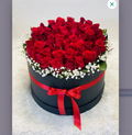 Luxury red roses arranged in black round box with red satin bow
